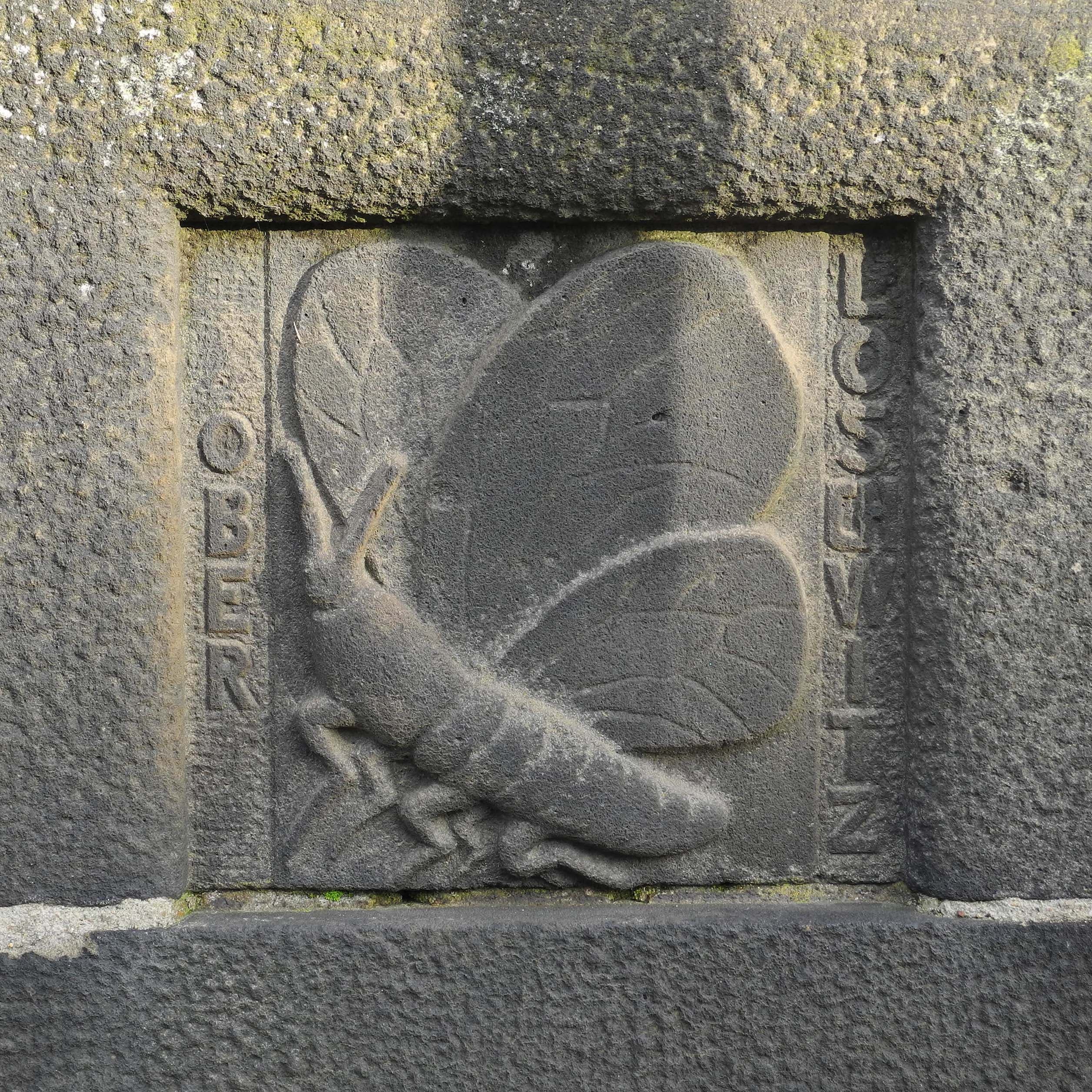 Stone carving of a butterfly and caterpillar